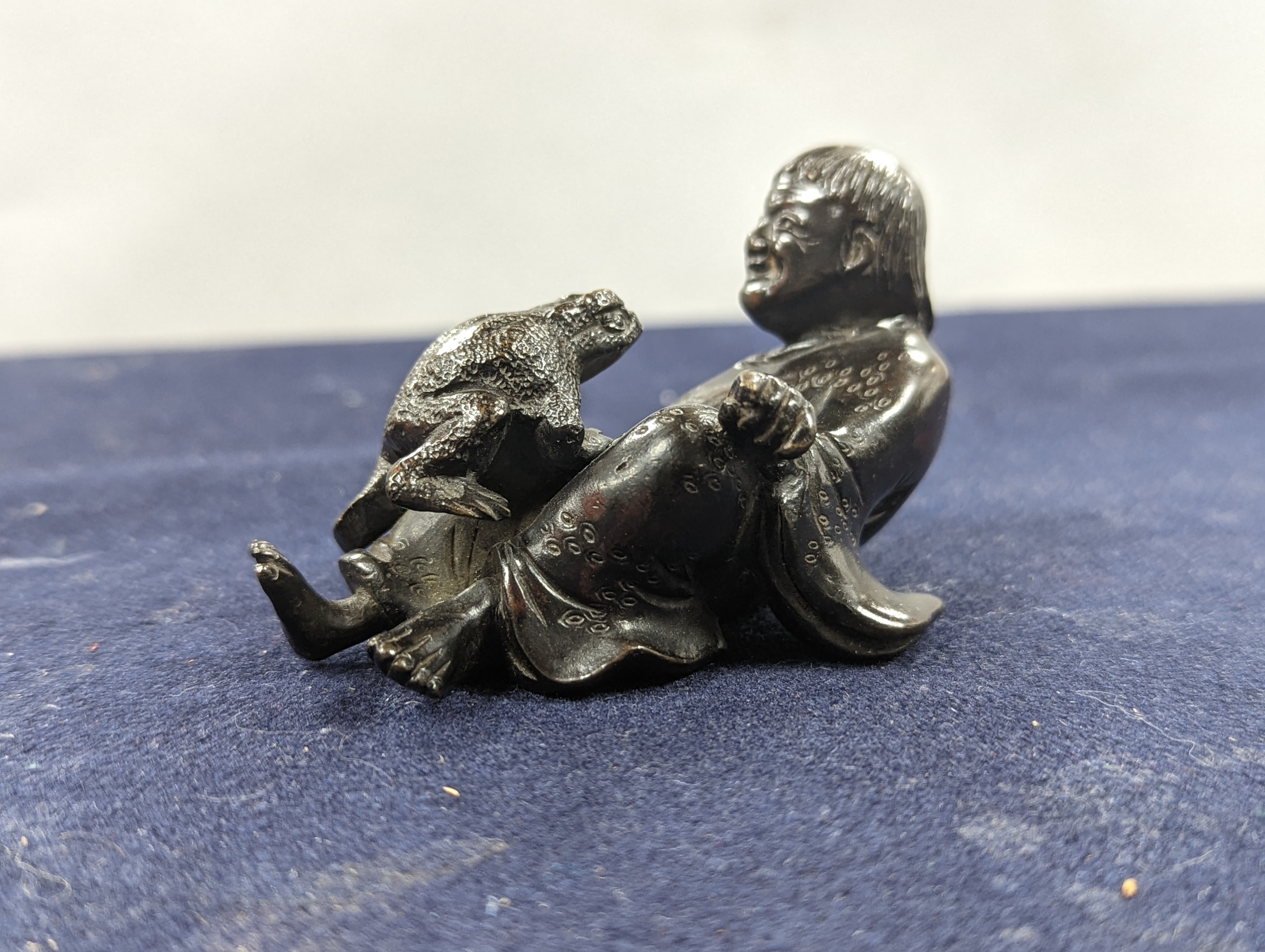 A Chinese bronze group of Liu Hai and a toad, wood stand and a bronze figure of a dog, 9cm